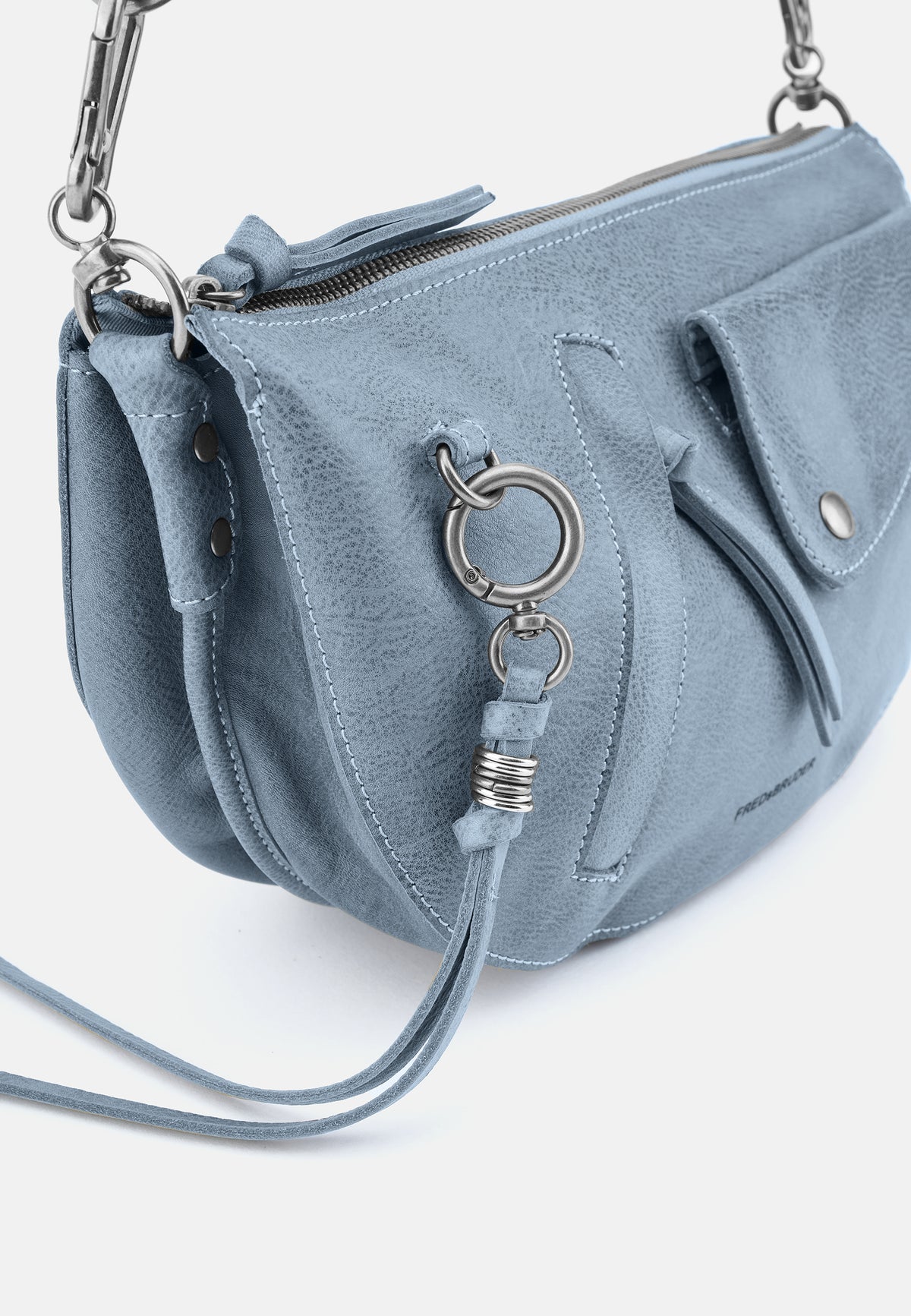 Nahaufnahme hellblaue Tasche mit Metallring und Reißverschlussvorderseite.