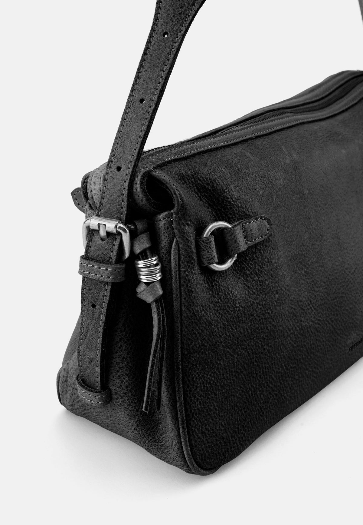 Detail der Schultertasche: Riemen mit Schnalle, Metallring und Quaste am Seitenfach.
