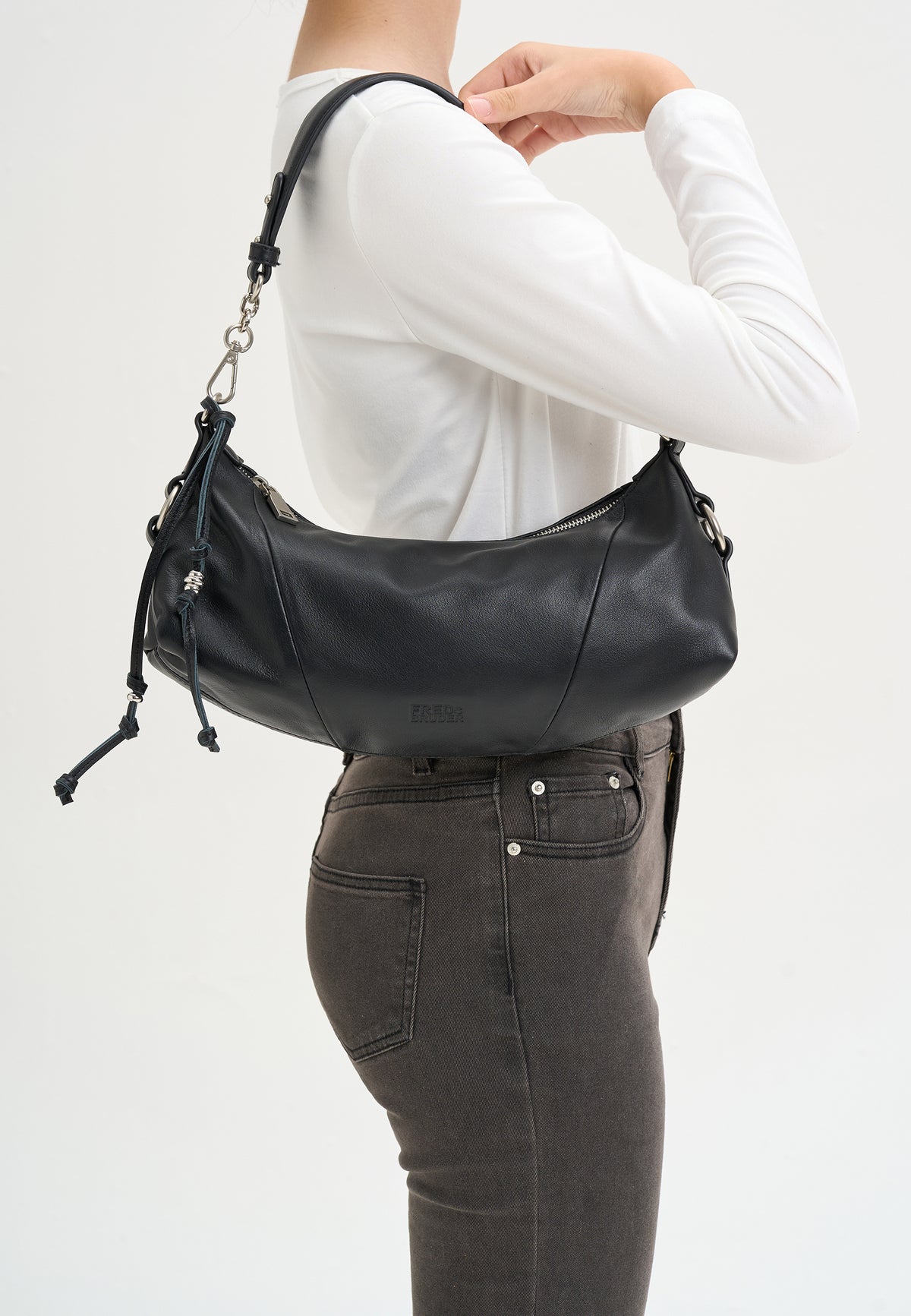 Schultertasche schwarz am Körper getragen, mit Kettenriemen und Reißverschlussfach oben