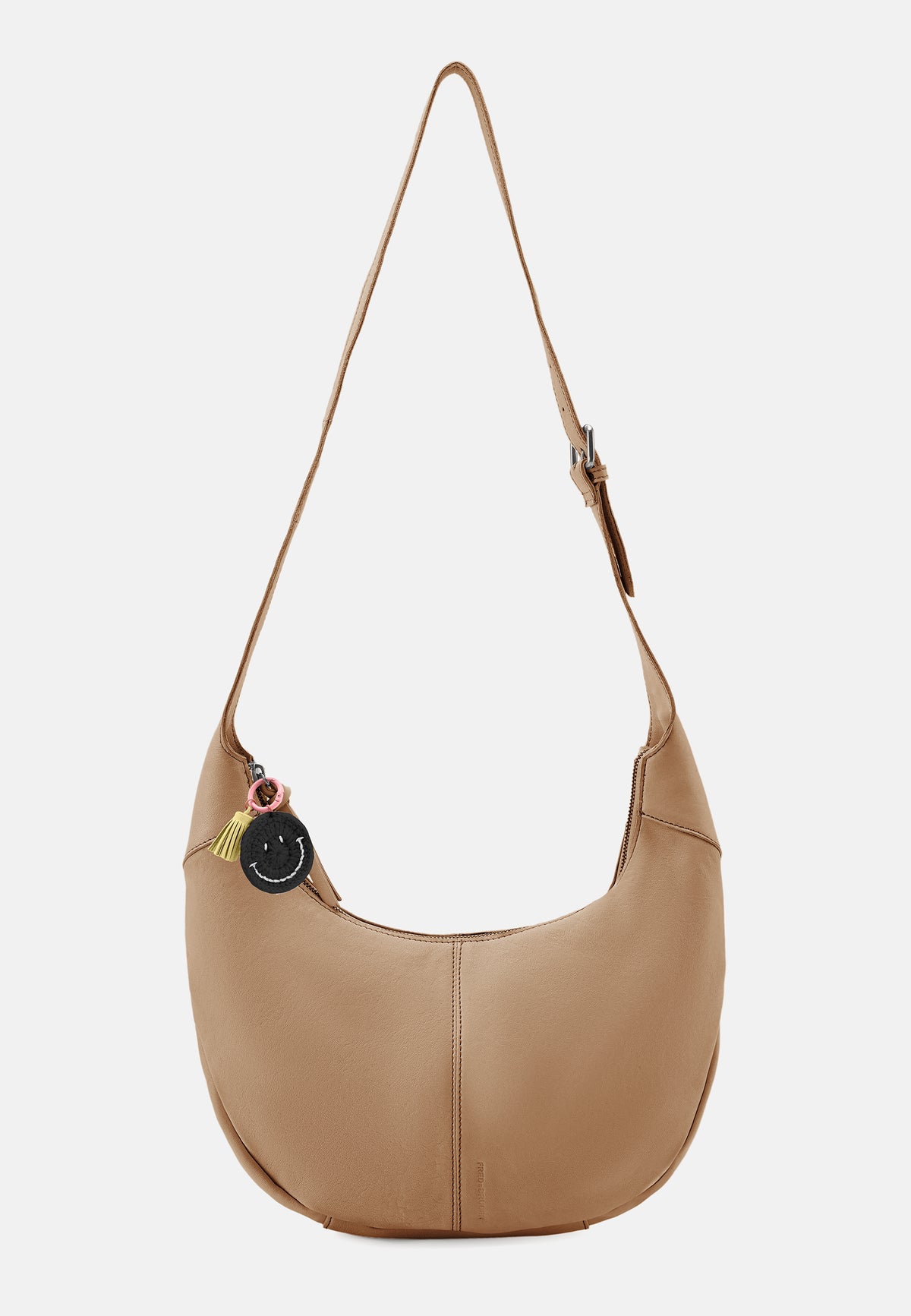 Braune Hobo-Tasche mit Schultergurt und rundem Anhänger am Außenbereich