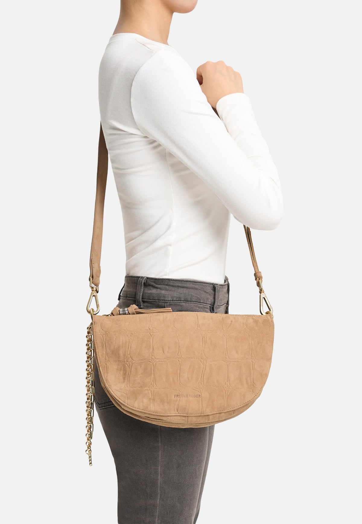 Khakifarbene Crossbody-Tasche seitlich am Modell getragen, mit Kettenriemen