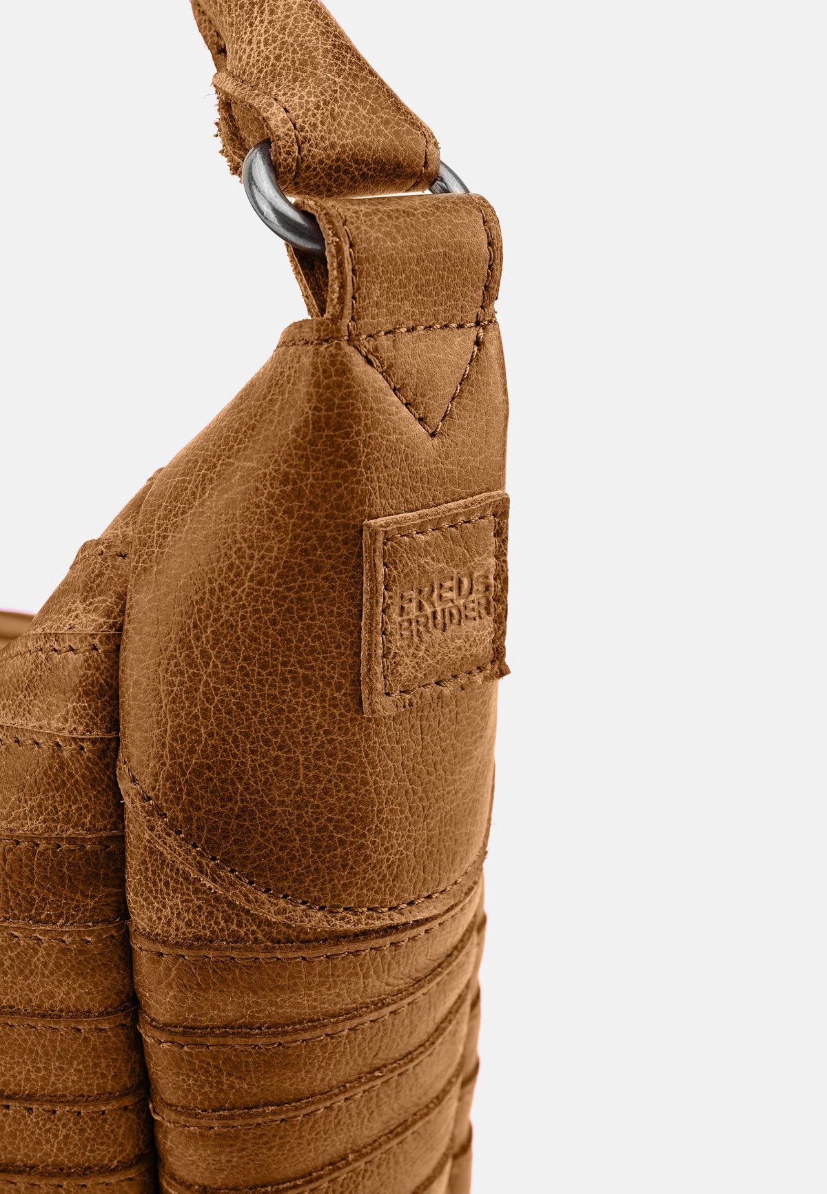 Hobo-Tasche in Desert-Brown: Detail am Trageriemen und Markenpatch