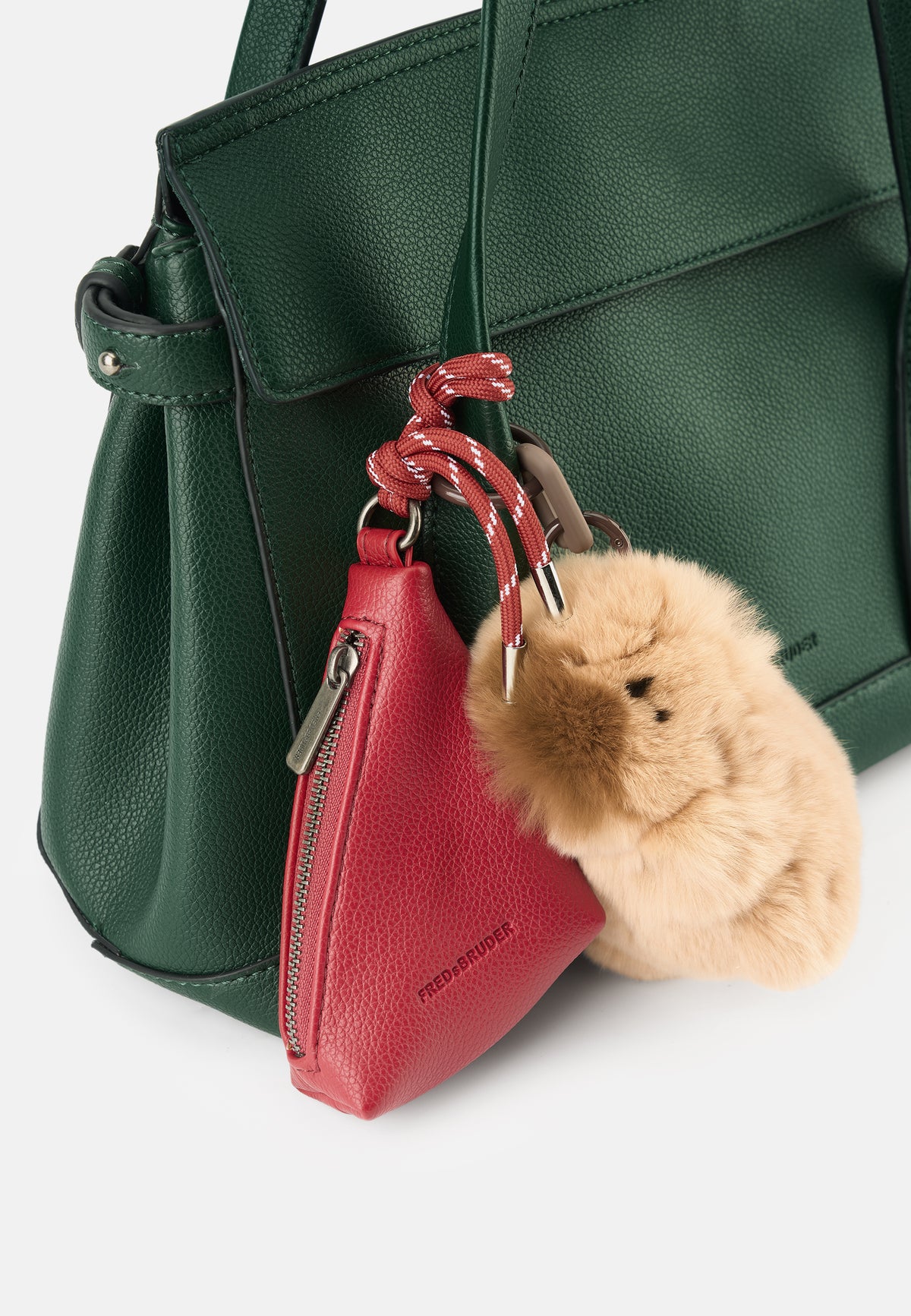Handtasche in Dunkelgrün mit rotem Anhänger und Plüsch-Schlüsselanhänger