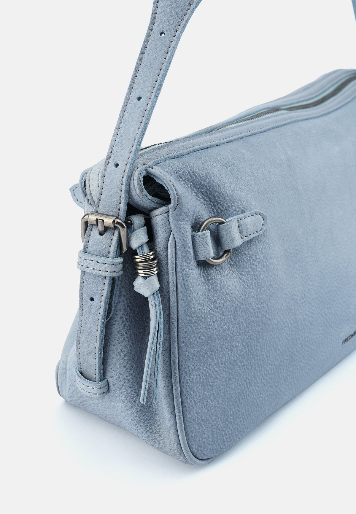 Detail: Hellblauer Riemen mit Schnalle, Metallring und Quaste an der Schultertasche.