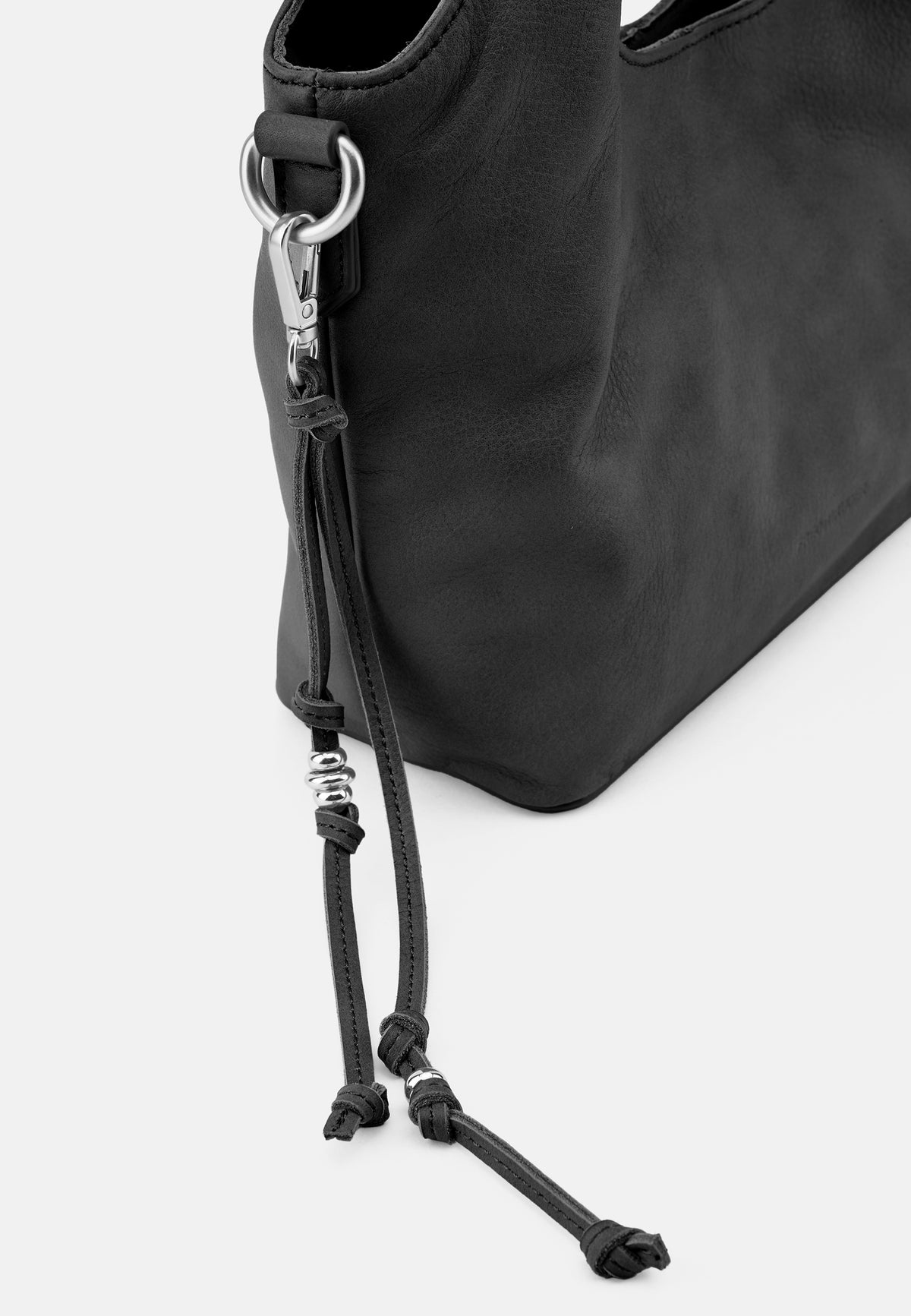Handtasche (schwarz) Detail: Metallöse, Reißverschluss und längenverstellbarer Schultergurt